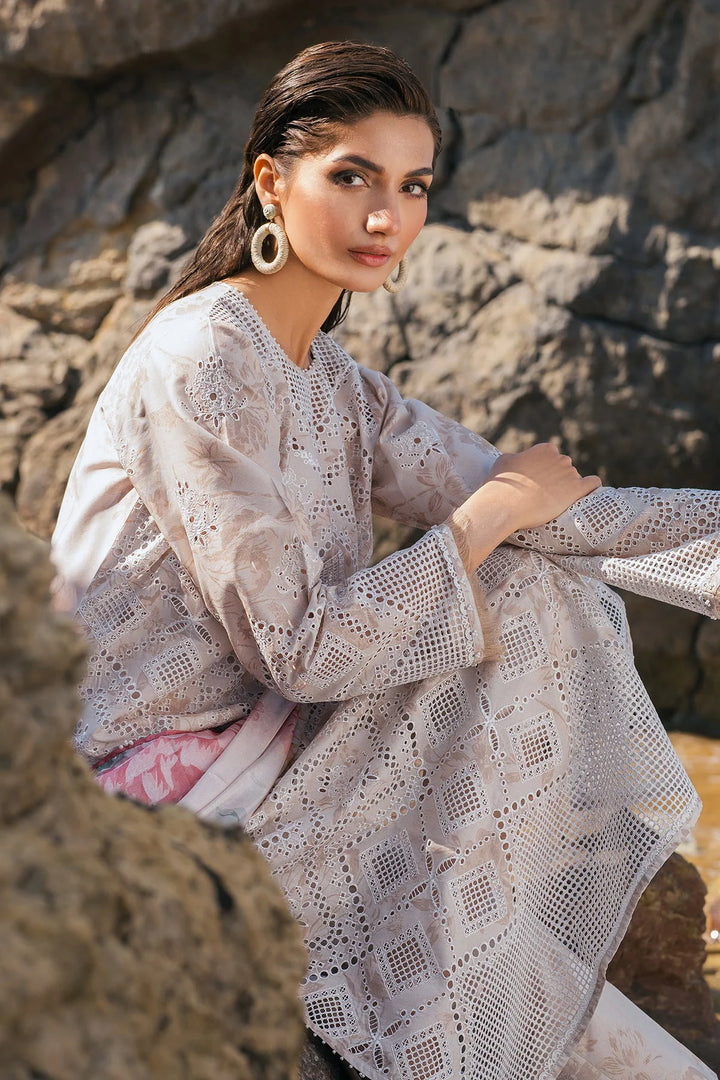 sitting down pose of Schiffli embroidered lawn shirt with floral printed dupatta and trouser

