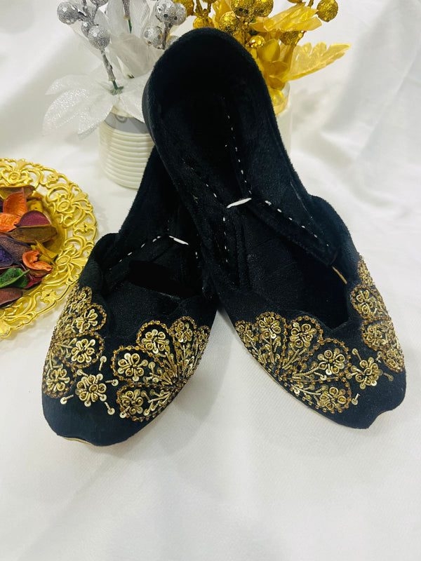 Handcrafted black khussas with intricate gold embroidery and cushioned lining – festive women’s footwear