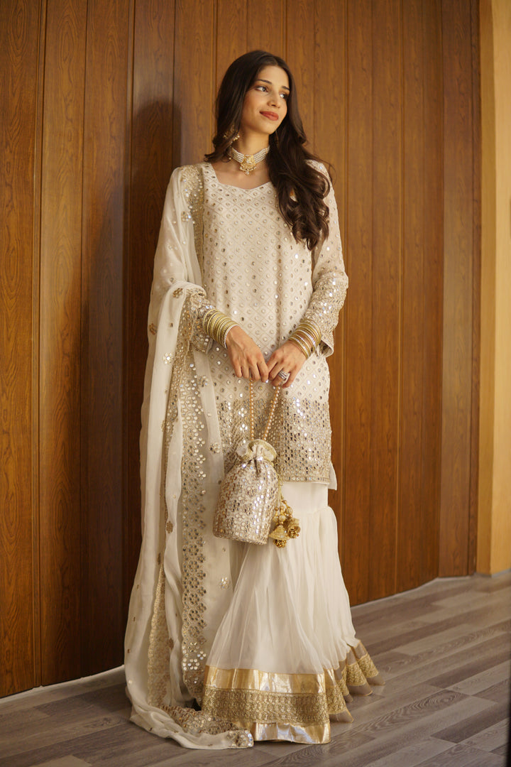 Bridal 8-piece wedding collection with hand-embroidered gharara, matching potli bag, khussa shoes, and jewelry.