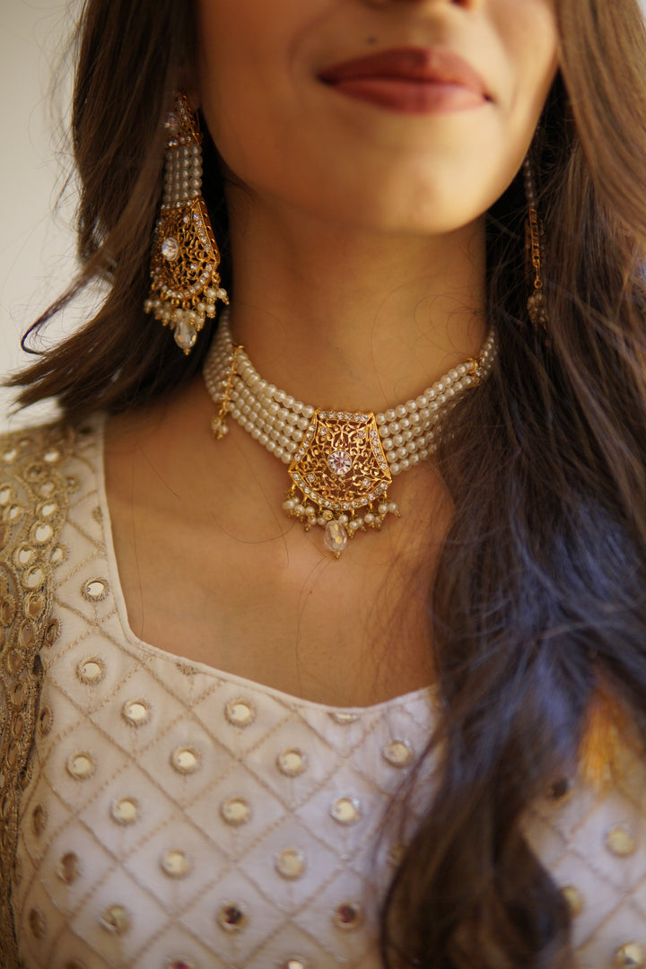 Elegant mehndi outfit set including embroidered gharara, festive potli, khussa flats, and jewelry accessories.