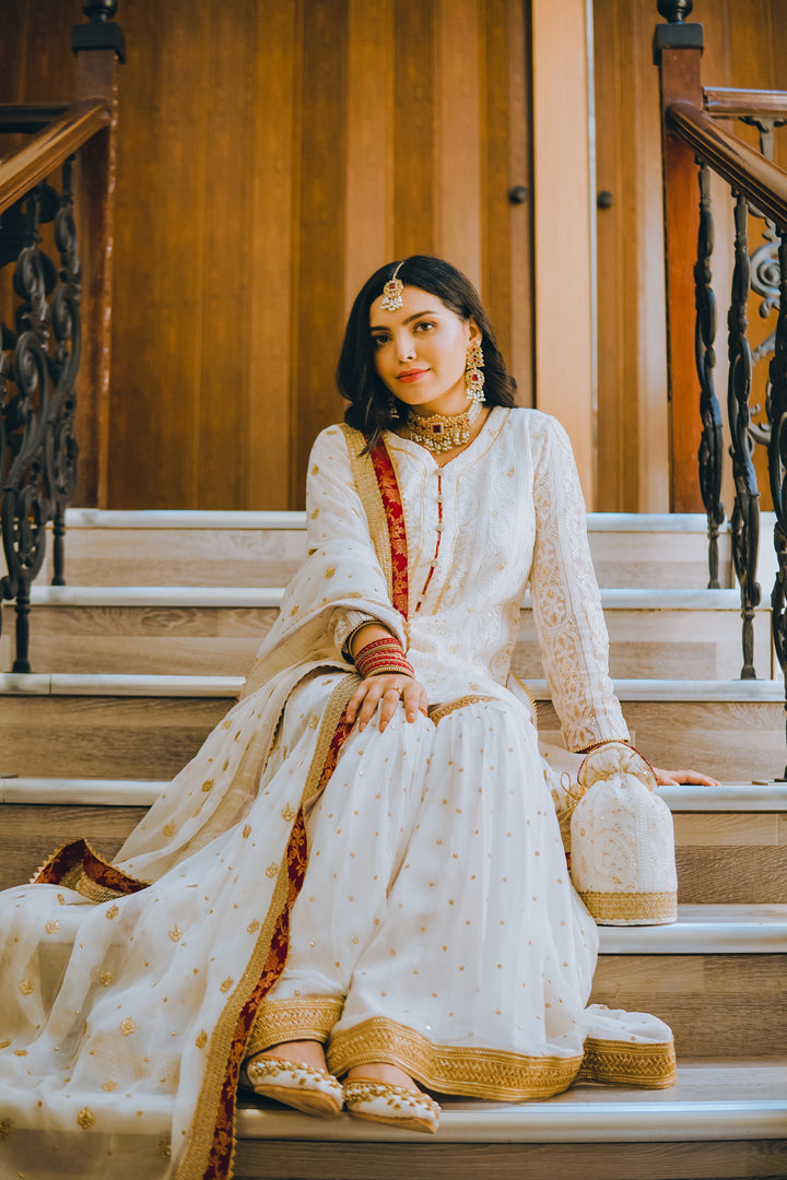 Naaz by Nazia bridal collection with 8 coordinated pieces: gharara outfit, dupatta, potli bag, khussa flats, and matching jewelry – ideal for mehndi.