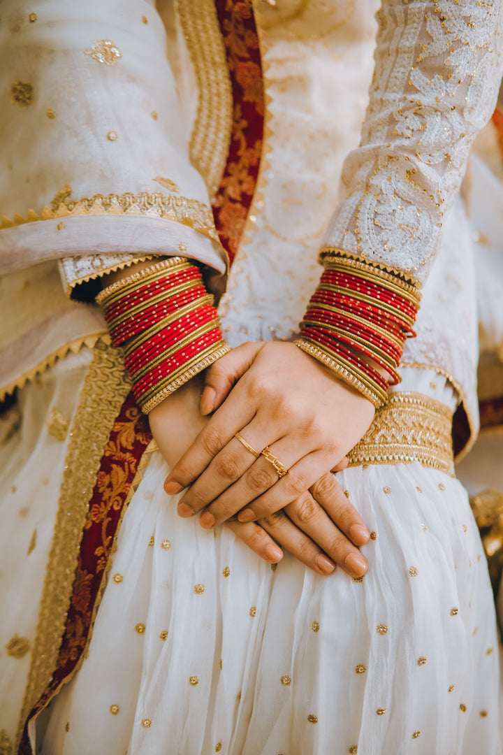 Complete Pakistani wedding trousseau featuring gharara, dupatta, potli clutch, khussa shoes, and jewelry for nikaah events.