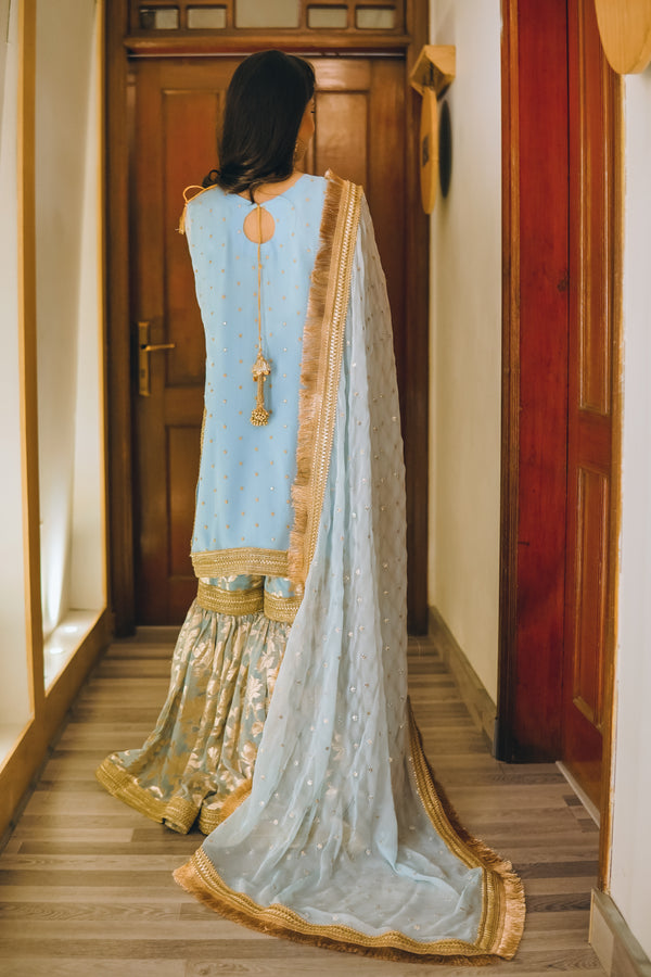 Designer 8-piece bridal set with gharara, potli bag, khussa footwear, and statement jewelry for mehndi or festive functions.
