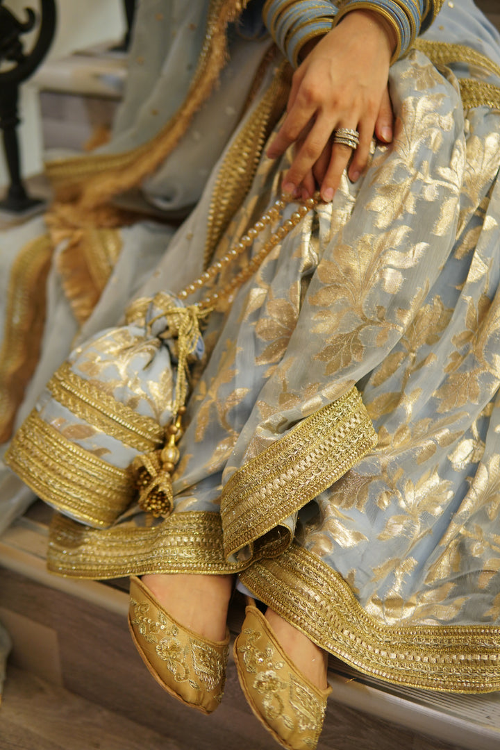 Luxury South Asian bridal ensemble with gharara suit, potli handbag, khussa footwear, and jewelry – ideal for Diwali celebrations.