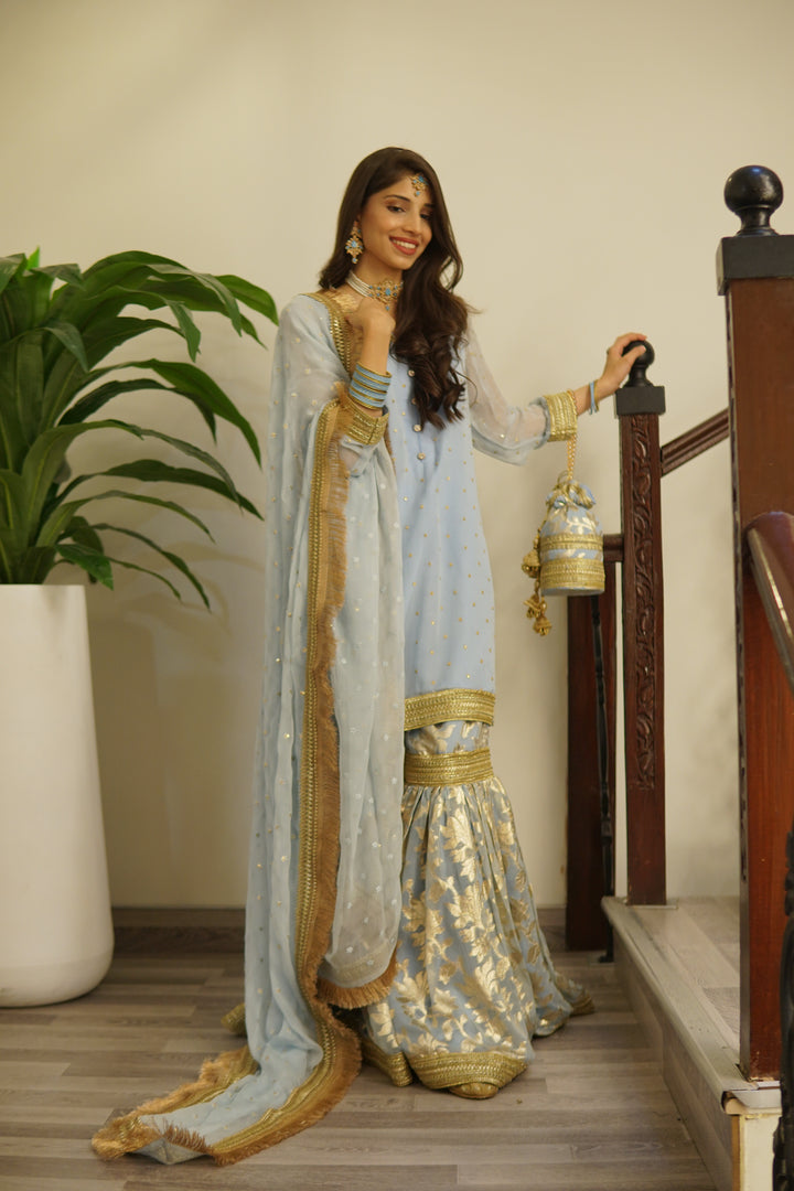 Designer 8-piece bridal set with gharara, potli bag, khussa footwear, and statement jewelry for mehndi or festive functions.