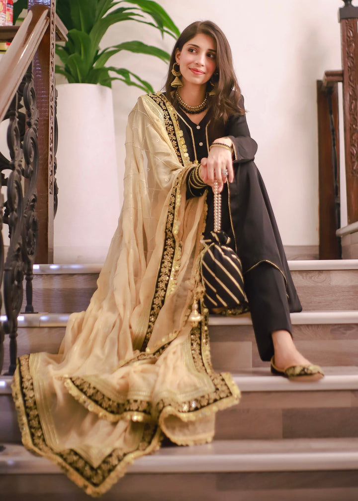 Elegant mehndi outfit set including embroidered gharara, festive potli, khussa flats, and jewelry accessories.