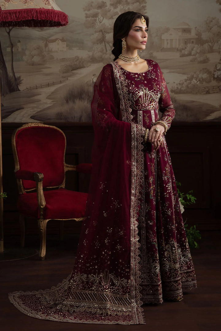 Model holding dupatta in traditional bridal pose wearing stitched maroon gown NEL-72

