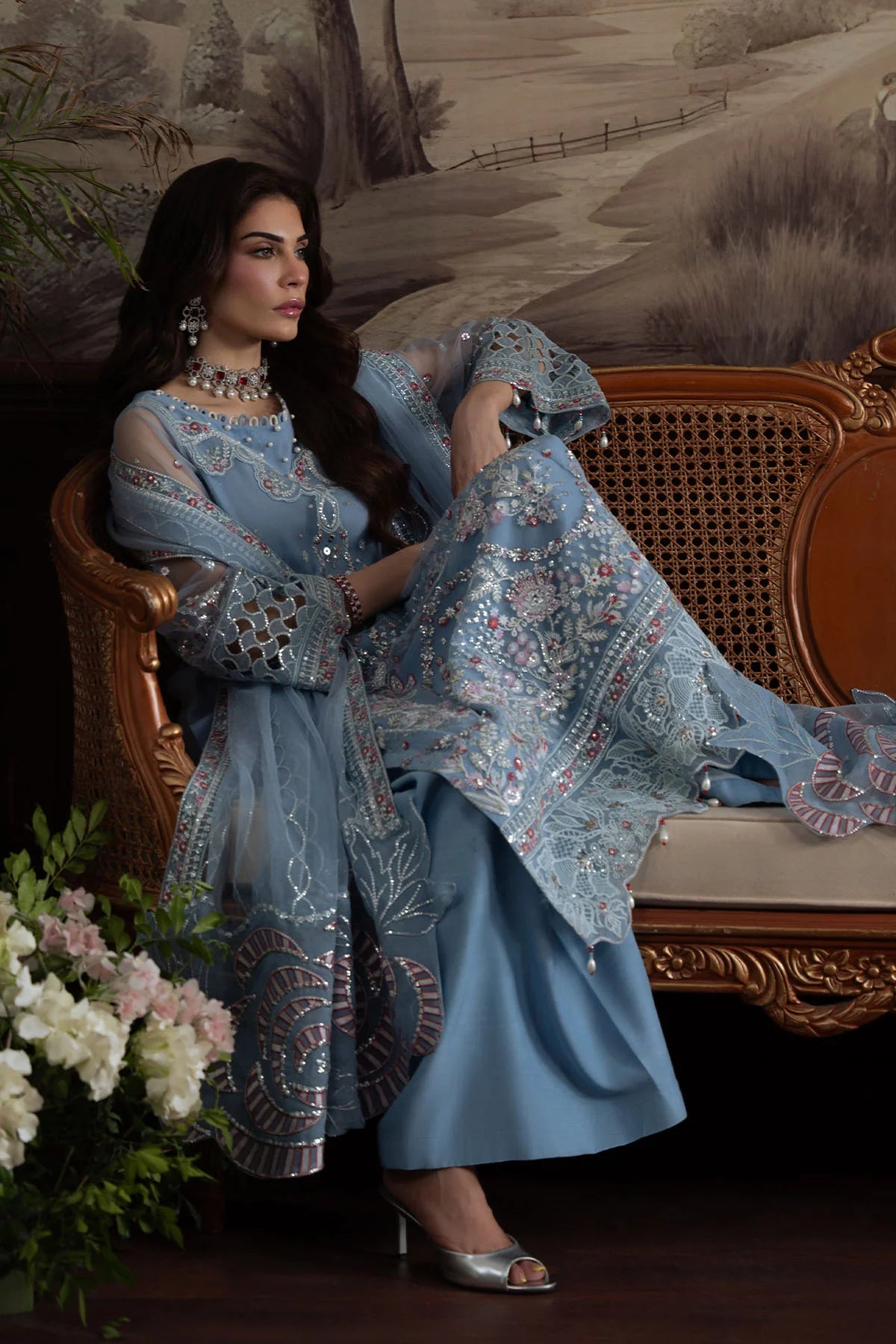 Model sitting in Nureh Elanora Style 74 embellished blue net outfit with embroidered dupatta