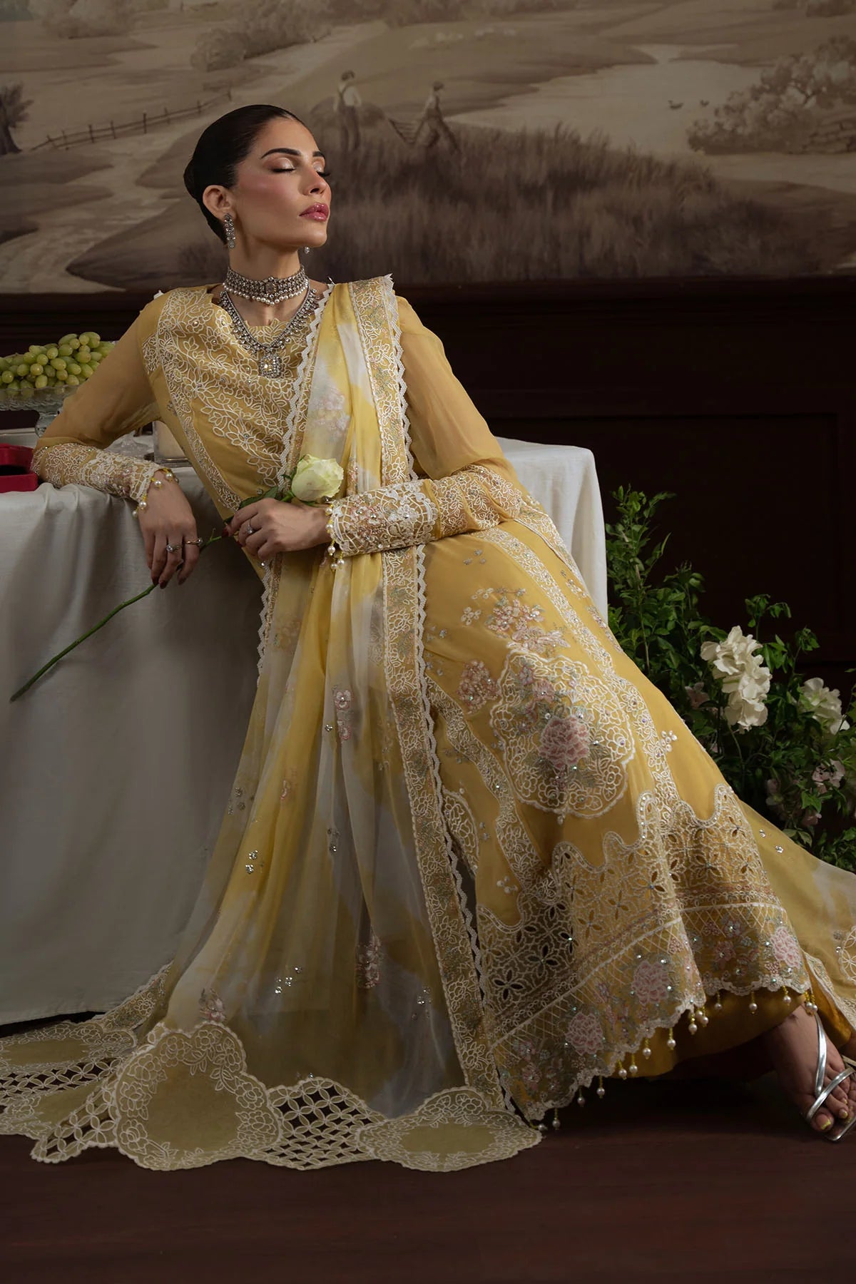 Model reclining in Nureh Style 76, highlighting the flow and detail of the embroidered chiffon fabric.