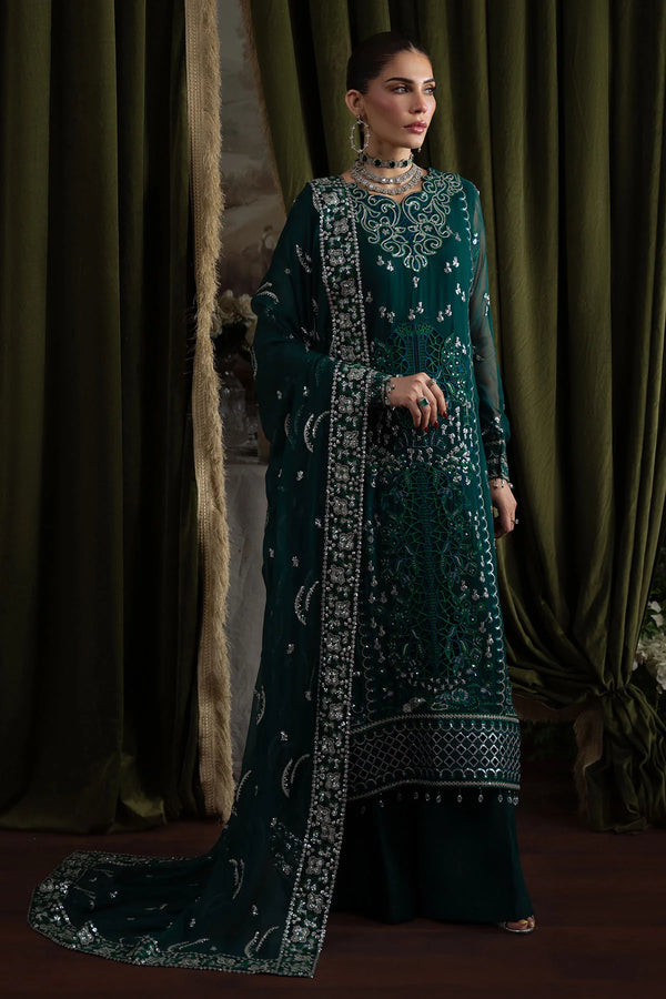 Model wearing deep green embroidered chiffon suit with heavily embellished dupatta in an elegant standing pose